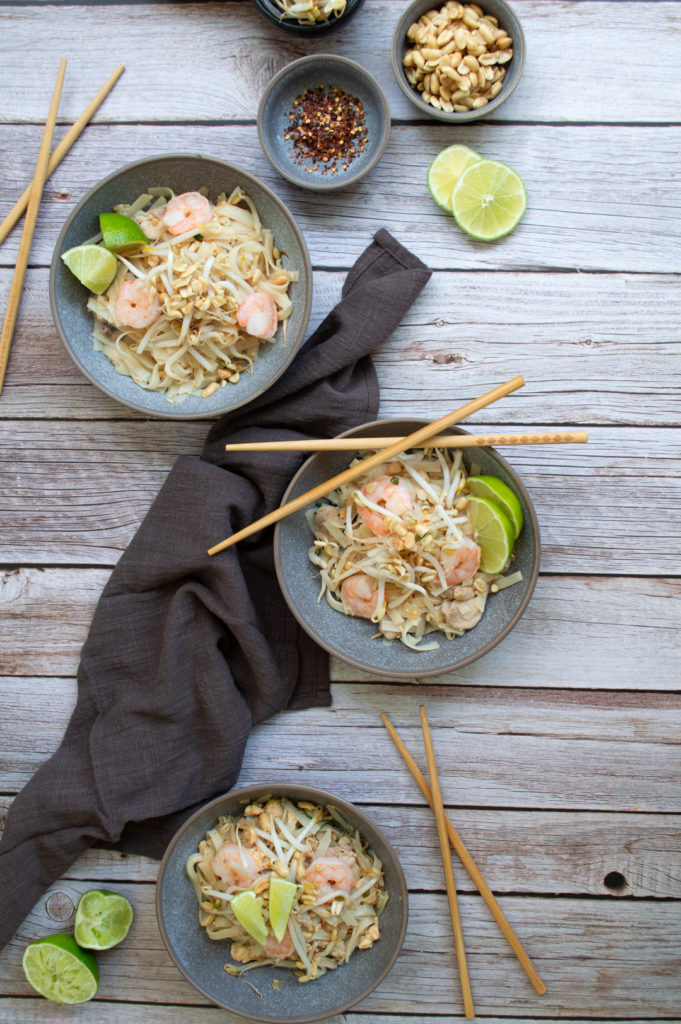 Table top food photography of 3 plates of Pad thai