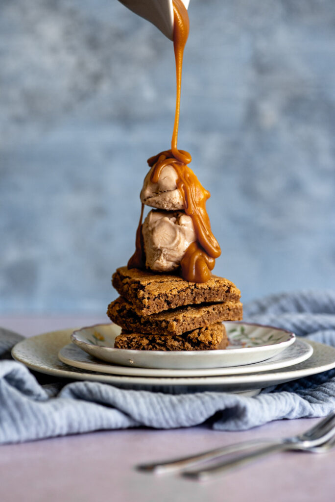 An image showcasing the toffee sauce pouring over some brownies.